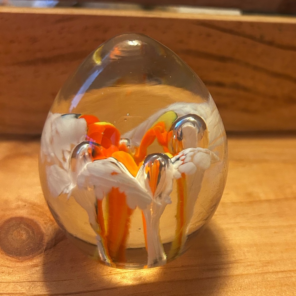 Vintage egg shaped blown glass paperweight with orange flower design in glass